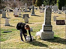 Madelyn tries to pick up a fallen headstone.